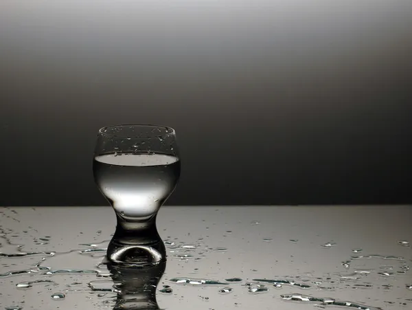 Verre d'eau - eau renversée Images De Stock Libres De Droits