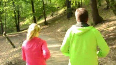 iki sporcu (kadın ve erkek) orman - steadicam çalıştırmak