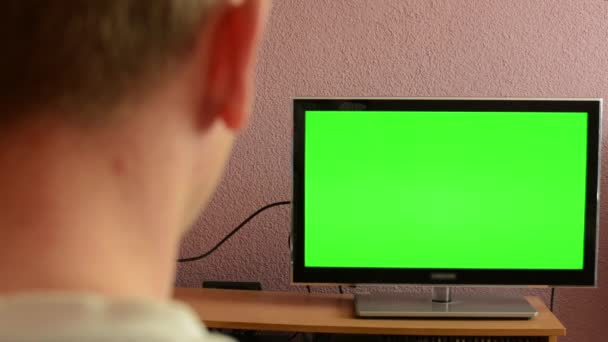 Man horloges tv(television) - groen scherm — Stockvideo