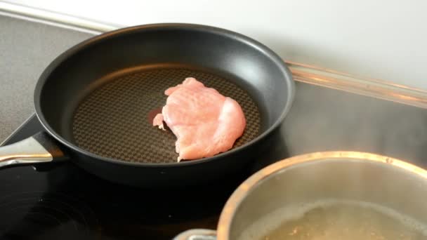 Mann kocht Fleisch - legt Fleisch in die Pfanne — Stockvideo