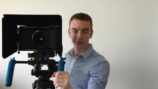 Man films met professionele camera en glimlach — Stockvideo