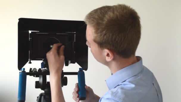 Чоловік очищає професійну камеру і посмішку — стокове відео