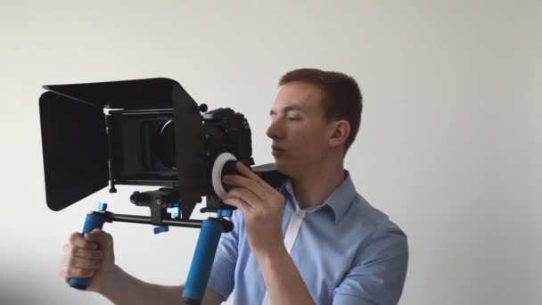 Man films met professionele camera en glimlach — Stockvideo