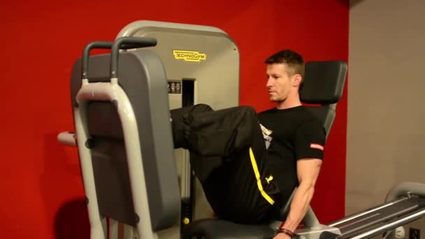 L'uomo rafforza i muscoli delle gambe in fitness, palestra. Allenamento — Video Stock