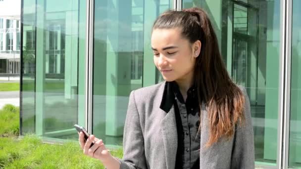 Femme d'affaires regarde le mobile avant le bâtiment de Bussines — Video