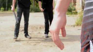 yumruk kavga iki saldırgan karşı-olan bir adam ona karşı saldırganların gidin, defender yumruğunu - dışında orman kum üzerinde clenches.