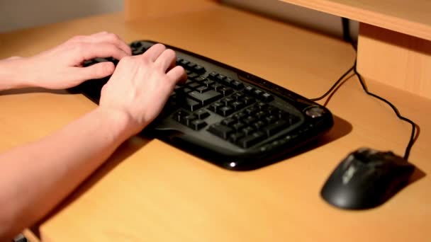 Handen (jonge man) schrijft op het toetsenbord en muis op de tabel in kamer gebruikt — Stockvideo