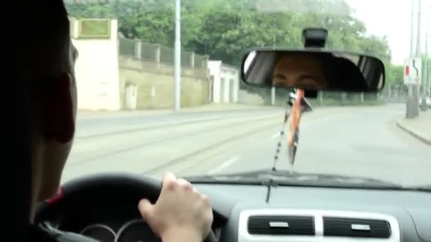 Un hombre conduce un coche - calle urbana en el fondo — Vídeo de stock