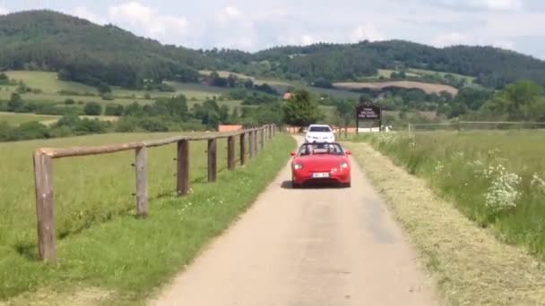 Homem e mulher viajam em um carro conversível na estrada - natureza no fundo . — Vídeo de Stock