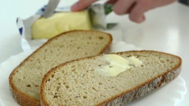 adam ekmek tereyağı ile yayılır.
