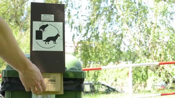 Cesta con bolsas de perro (excremento) - naturaleza en el fondo - el hombre toma una bolsa — Vídeo de stock