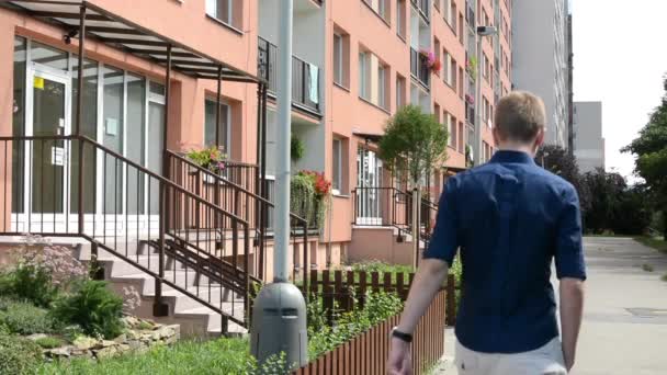 Housing estate (development) -entrance to the building with nature and man goes — Stock Video