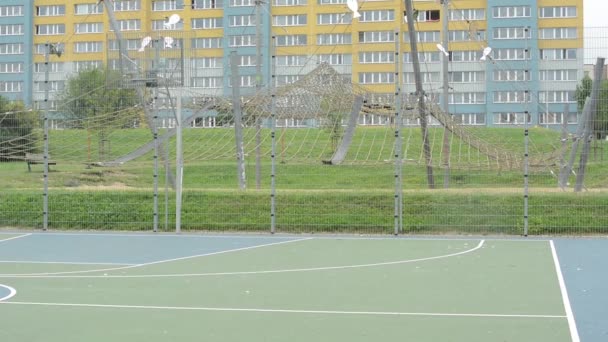 Детская площадка и веревочный центр с квартирами на заднем плане — стоковое видео
