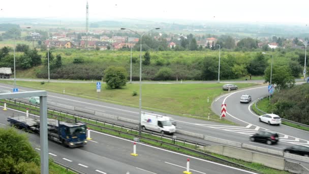 Motorväg med utgång från road och bilar - staden i bakgrunden — Stockvideo