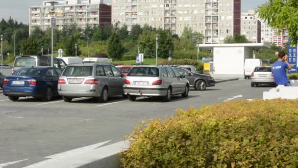 Parkeerterrein met auto's en gebouw in de achtergrond — Stockvideo
