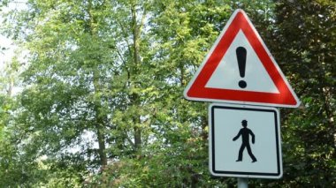 trafik işaretleri - attention:pedestrian(walkers) - yeşil ağaçlar arka planda