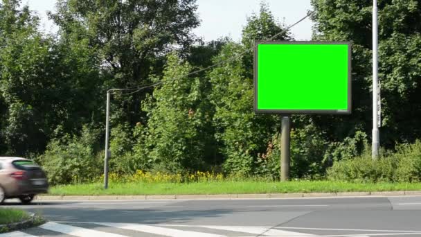 Cartelera - pantalla verde - calle urbana con coches de paso y la naturaleza (árboles y hierba) en el fondo — Vídeo de stock