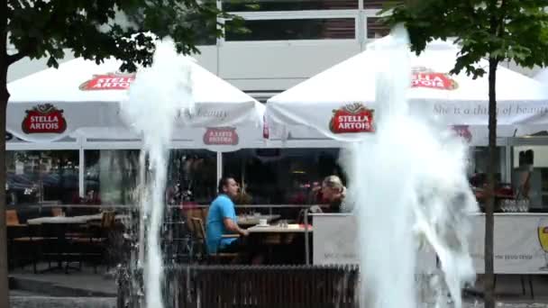 Restaurant - outside seating - couple (men and women). Fountain in foreground — Stock Video