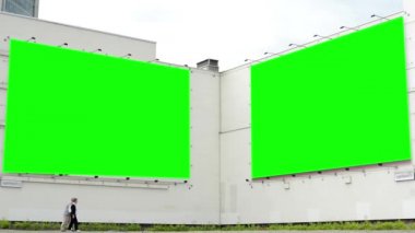 üzerinde büyük bir Billboard - yeşil ekran - iki eski yürüyen insan - doğa ile bulutlu gökyüzü bina.