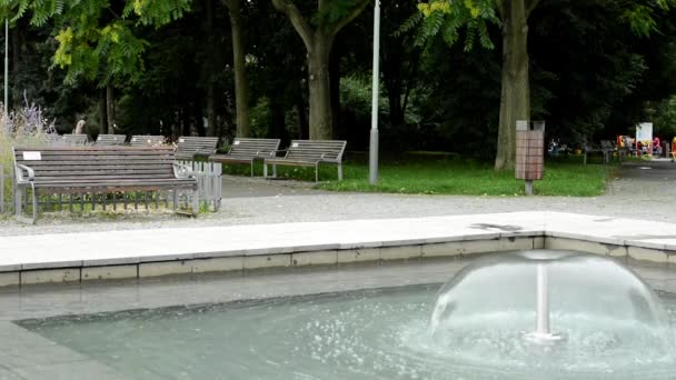 Brunnen - Park mit Bänken und Bäumen im Hintergrund — Stockvideo