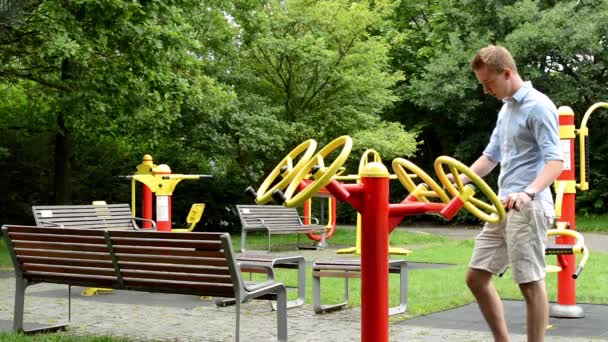 Senior park (macchine da ginnastica) con panchine - nel parco - l'uomo rafforza — Video Stock