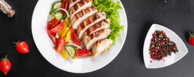 Salata, tavuk göğsü, kümes hayvanları, salatalık, soğan, biber, zeytin yağı, marul yaprağı taze porsiyonları fotokopi masasında atıştırmaya hazır.