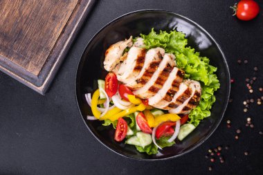 Salata, tavuk göğsü, kümes hayvanları, salatalık, soğan, biber, zeytin yağı, marul yaprağı taze porsiyonları fotokopi masasında atıştırmaya hazır.