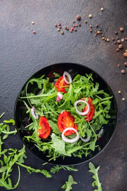 Arugula ve domates salatası sebzesi tabakta taze yemek atıştırmalığı fotokopi uzayı arka planı kırsal vejetaryen yemeği veya vejetaryen yemeği.