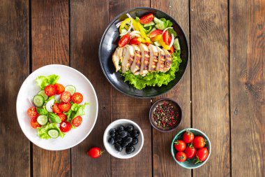 Masa menüsündeki farklı salata türleri sebzeler, et, salata... Atıştırmalık yemeye hazır taze porsiyon... üst görünüm keto veya paleo diyeti