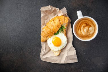 Kızarmış yumurta kruvasanı, sebze salatası domates, salatalık hazır yemek atıştırmalığı fotokopi masasında uzay yemeği arka plan kırsal keto veya paleo diyet vejetaryen yemeği 