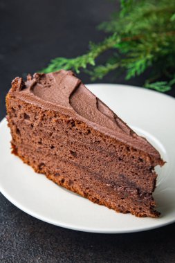 Bir parça çikolatalı kek kakaolu kek, çikolatalı ganache, kahverengi kremalı tatlı hazır sofrada atıştırmaya hazır uzay yemeği arka planında kırsal. en üstteki görünüm