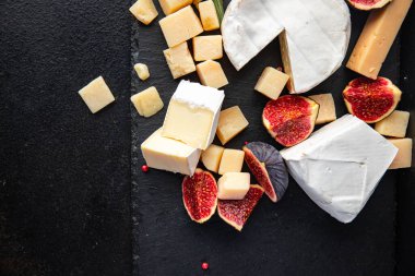 Peynir tabağı çeşitli peynirler aperatif antipasto brie, camembert, çedar, parmesan ve diğer şeyler masada atıştırmaya hazır fotokopi uzayı arka plan kırsalında. en üstteki görünüm