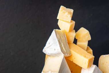 Peynir tabağı çeşitli peynirler aperatif antipasto brie, camembert, çedar, parmesan ve diğer şeyler masada atıştırmaya hazır fotokopi uzayı arka plan kırsalında. en üstteki görünüm