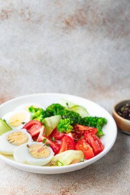Salata kasesi haşlanmış yumurta, brokoli, domates, salatalık, sebzeler fotokopi masasında atıştırmalık uzay yemeği arka plan vejetaryen ya da vejetaryen 