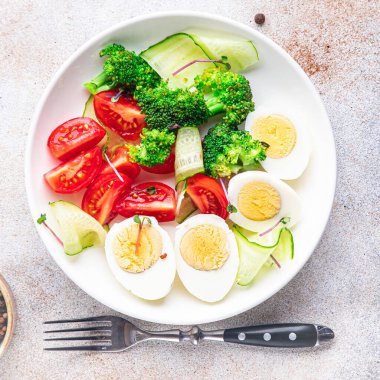 Salata kasesi haşlanmış yumurta, brokoli, domates, salatalık, sebzeler fotokopi masasında atıştırmalık uzay yemeği arka plan vejetaryen ya da vejetaryen 