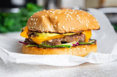 Hamburger klasik ev yapımı rulo, peynir, sebze, ızgara pirzola kıymalı domuz eti, sığır eti veya dana eti, masa başı yiyecek arka plan kırsalında atıştırmaya hazır. en üstteki görünüm