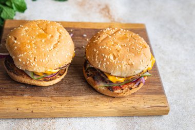 Hamburger klasik ev yapımı rulo, peynir, sebze, ızgara pirzola kıymalı domuz eti, sığır eti veya dana eti, masa başı yiyecek arka plan kırsalında atıştırmaya hazır. en üstteki görünüm