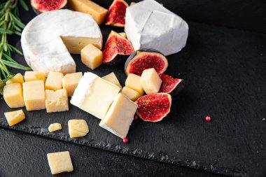 Peynir tabağı çeşitli peynirler aperatif antipasto brie, camembert, çedar, parmesan ve diğer şeyler masada atıştırmaya hazır fotokopi uzayı arka plan kırsalında. en üstteki görünüm