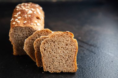 Yulaf ekmeği kepekli buğday, maya yok. Masada atıştırmalık bir şeyler var. Fotokopi masası arka planında.