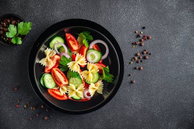 Farfalle makarna salatası, domates, salatalık, soğan sağlıklı beslenme aperatifi fotokopi uzayı arka plan kırsalında. Vejetaryen vejetaryen ya da vejetaryen et yok.