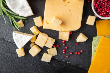 Peynir tabağı çeşitli peynir, peynirli peynir, peynirli peynir, parmesan peyniri, çedar ve diğer sağlıklı beslenme diyeti atıştırmalıkları masa arkası yiyecek arka plan kırsalında. en üstteki görünüm