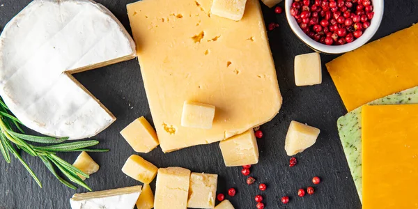 Peynir tabağı çeşitli peynir, peynirli peynir, peynirli peynir, parmesan peyniri, çedar ve diğer sağlıklı beslenme diyeti atıştırmalıkları masa arkası yiyecek arka plan kırsalında. en üstteki görünüm