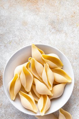 raw pasta Conchiglioni seashells mold form ingredient healthy meal food snack on the table copy space food background