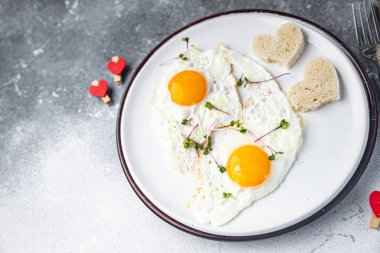 Masada sevgililer günü yumurta kahvaltısı yağda yumurta kalp şeklinde tatil dekorasyonu tarihi uzay yemeği arka planının fotokopisi