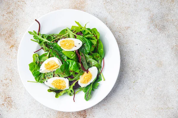 Paskalya salatası yumurta yeşil yapraklar taze porsiyon sağlıklı yemek atıştırmalıklarını masanın üzerinde fotokopi uzayı arka plan kırsal üst görüş keto veya paleo diyet vejetaryen yemeği et yok.