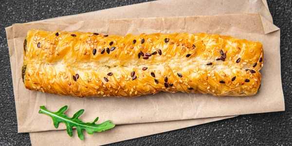 Rollini çeşnili hamur işleri ıspanak, peynirli börek taze fileto hamuru sağlıklı yemek hazır atıştırmalıklar masa arkasında uzay yiyeceklerinin fotokopisi. 