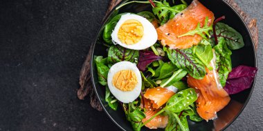 Salata somonu, yumurta, yeşil yaprak marul taze porsiyon sağlıklı yemek diyet atıştırmalığı fotokopi masasında 