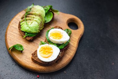 Yumurtalı sandviç avokado, kahvaltılık ekmek açık sandviç sağlıklı yemek fast food diyet aperatifi masa arkasında fotokopi uzay yemeği arka planı.