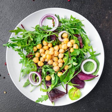 Nohut salatası yeşil yapraklı marul yaprakları taze porsiyon sağlıklı yemek diyet aperatiflerini masanın üzerinde fotokopi arka planında keto ya da paleo diyet vejetaryen vejetaryen ya da vejetaryen yemeği olmadan hazırlar.