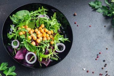 Nohut salatası yeşil yapraklı marul yaprakları taze porsiyon sağlıklı yemek diyet aperatiflerini masanın üzerinde fotokopi arka planında keto ya da paleo diyet vejetaryen vejetaryen ya da vejetaryen yemeği olmadan hazırlar.